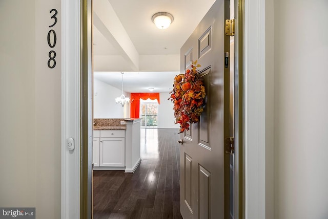 hall featuring a chandelier and dark hardwood / wood-style flooring