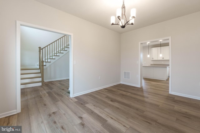 unfurnished dining area featuring a chandelier and light hardwood / wood-style flooring