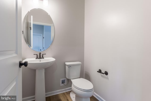 bathroom with toilet and hardwood / wood-style flooring