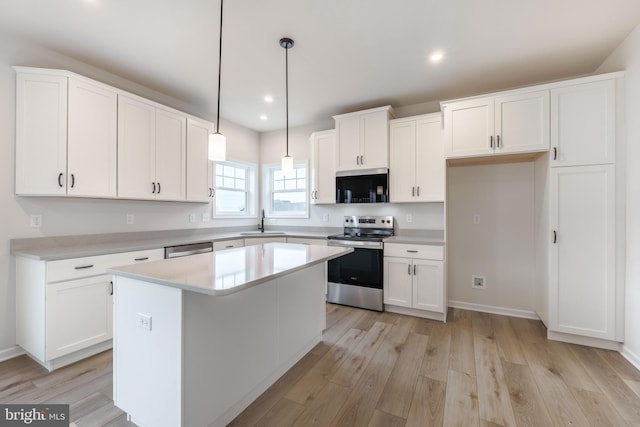 kitchen with sink, white cabinets, a center island, and stainless steel appliances