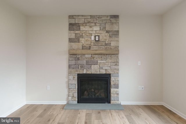 details featuring hardwood / wood-style flooring and a stone fireplace