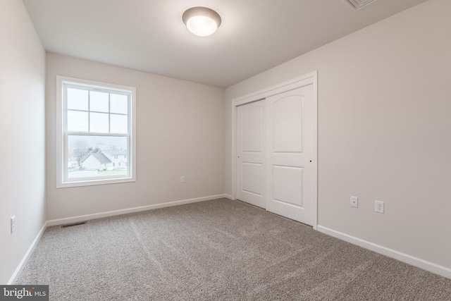 unfurnished bedroom with a closet and carpet flooring