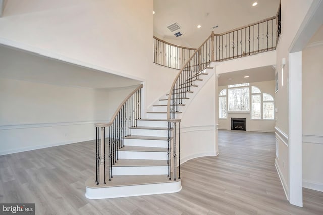 stairs featuring a high ceiling and wood-type flooring