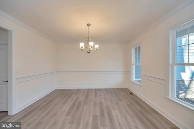 unfurnished dining area with a chandelier, crown molding, and light hardwood / wood-style floors