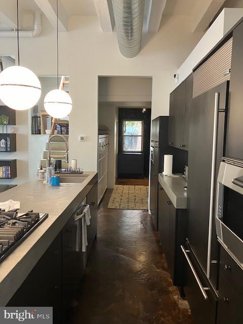 kitchen featuring pendant lighting, stainless steel microwave, and black gas cooktop