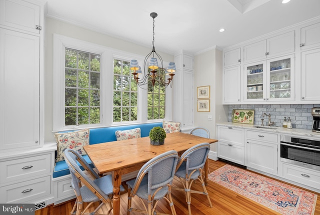 dining area featuring sink, breakfast area, light hardwood / wood-style flooring, and a healthy amount of sunlight