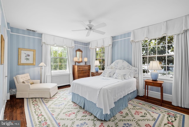 bedroom featuring ceiling fan, radiator heating unit, and hardwood / wood-style flooring