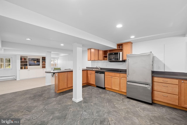 kitchen with a baseboard radiator, kitchen peninsula, sink, and stainless steel appliances