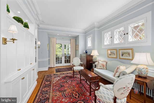 living room featuring hardwood / wood-style floors, crown molding, and french doors