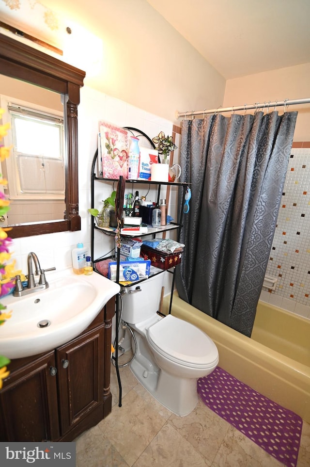 bathroom featuring toilet, shower / bath combo with shower curtain, and vanity