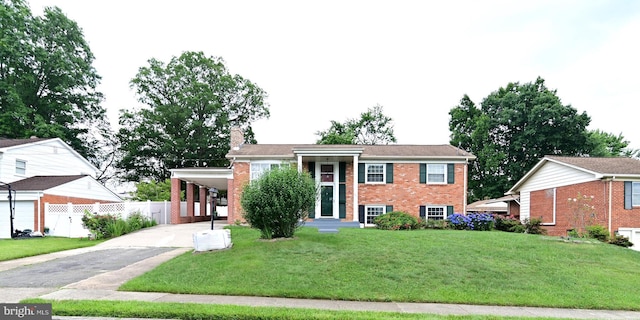 view of front of house with a front lawn, aphalt driveway, a carport, fence, and brick siding