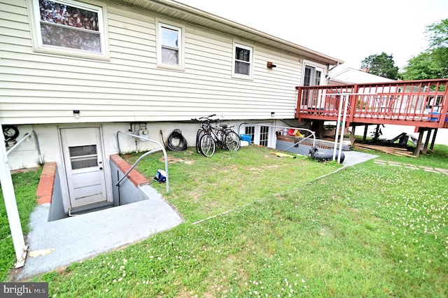 rear view of property featuring a yard and a wooden deck