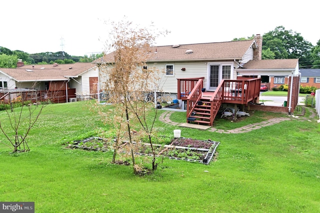 back of house with roof with shingles, a wooden deck, a vegetable garden, a chimney, and a lawn