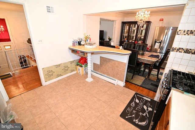 kitchen with visible vents, an inviting chandelier, crown molding, stainless steel fridge with ice dispenser, and a baseboard radiator