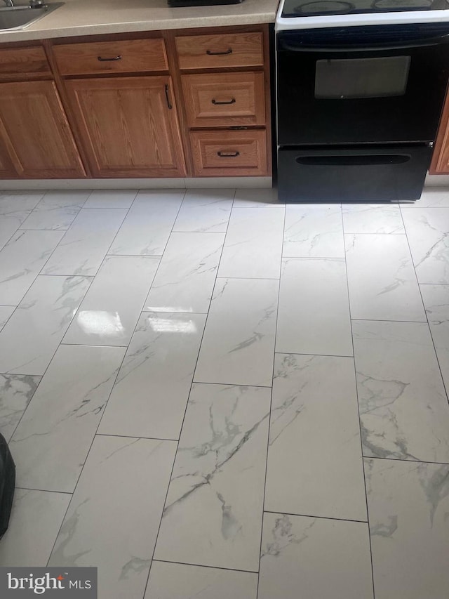 kitchen with sink, light tile patterned floors, and electric stove