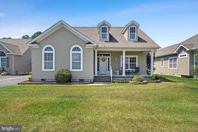 cape cod-style house featuring covered porch and a front lawn