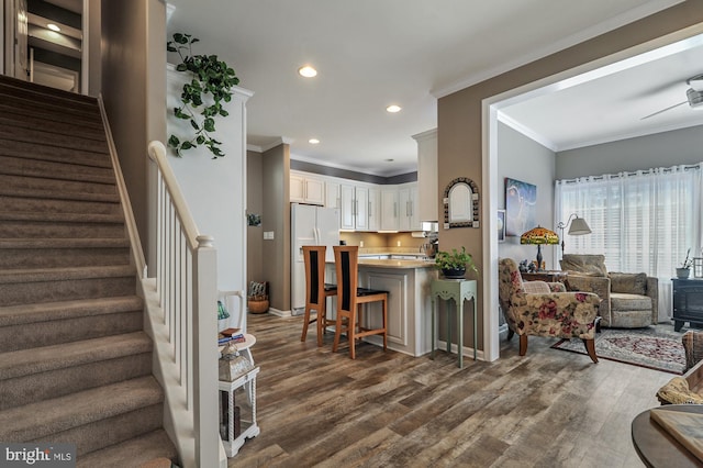 living room with ornamental molding, dark hardwood / wood-style floors, and ceiling fan