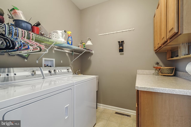 clothes washing area featuring cabinets, independent washer and dryer, and light tile patterned floors