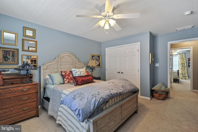 bedroom with light carpet, ceiling fan, and a closet