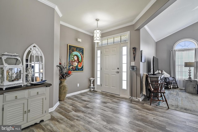 foyer entrance with lofted ceiling, hardwood / wood-style floors, and ornamental molding