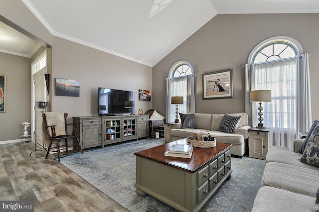 living room featuring vaulted ceiling, crown molding, plenty of natural light, and hardwood / wood-style floors