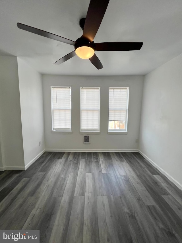 unfurnished room with ceiling fan and dark hardwood / wood-style flooring