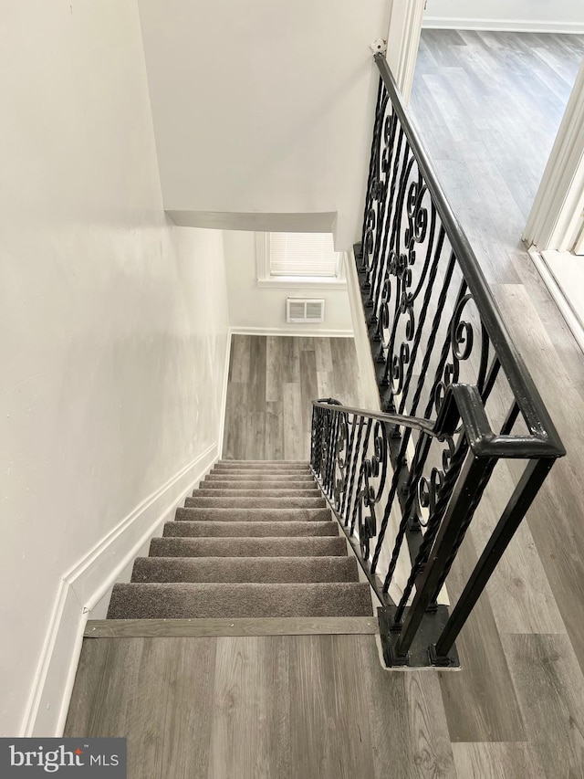 staircase with hardwood / wood-style flooring