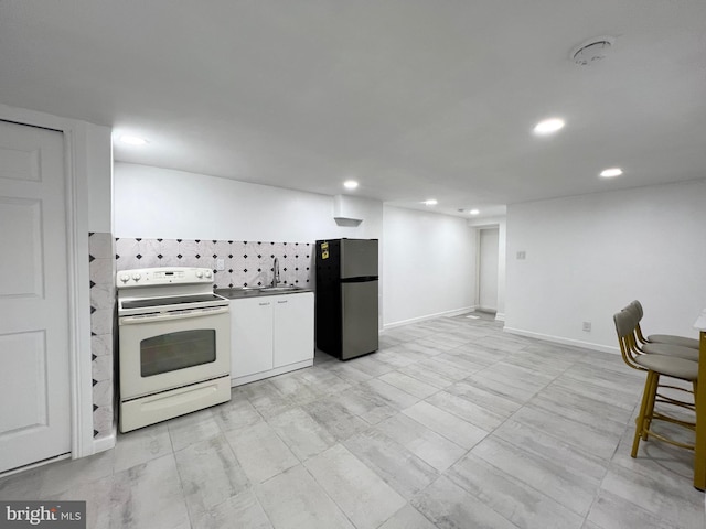 kitchen featuring white cabinetry, decorative backsplash, stainless steel refrigerator, white electric stove, and sink