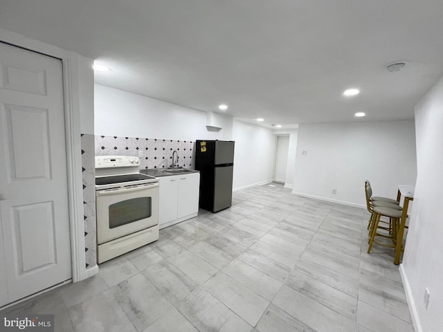 kitchen with white electric range oven, white cabinetry, tasteful backsplash, sink, and stainless steel fridge