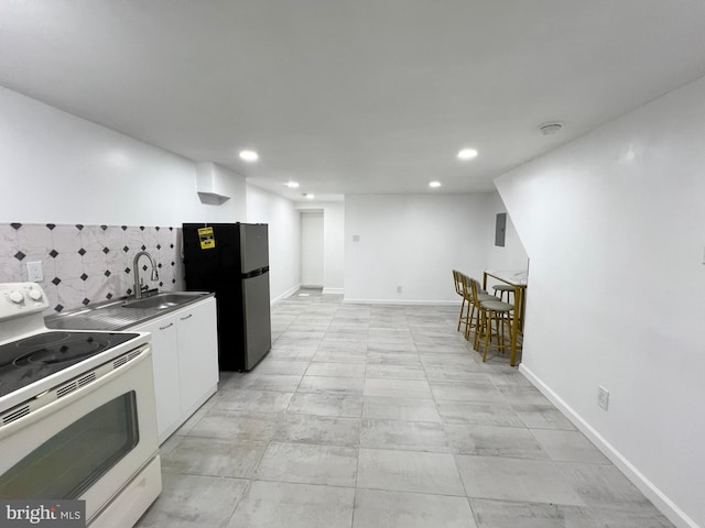 kitchen featuring white cabinets, white range with electric cooktop, decorative backsplash, sink, and stainless steel refrigerator