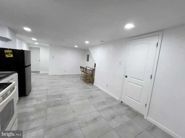 kitchen featuring stainless steel fridge and white range with electric cooktop