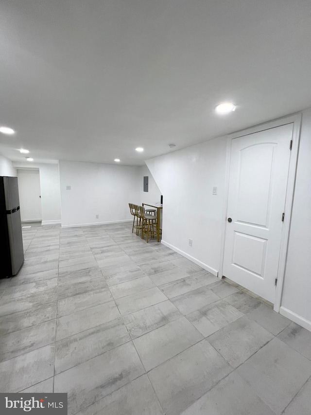 basement featuring stainless steel fridge