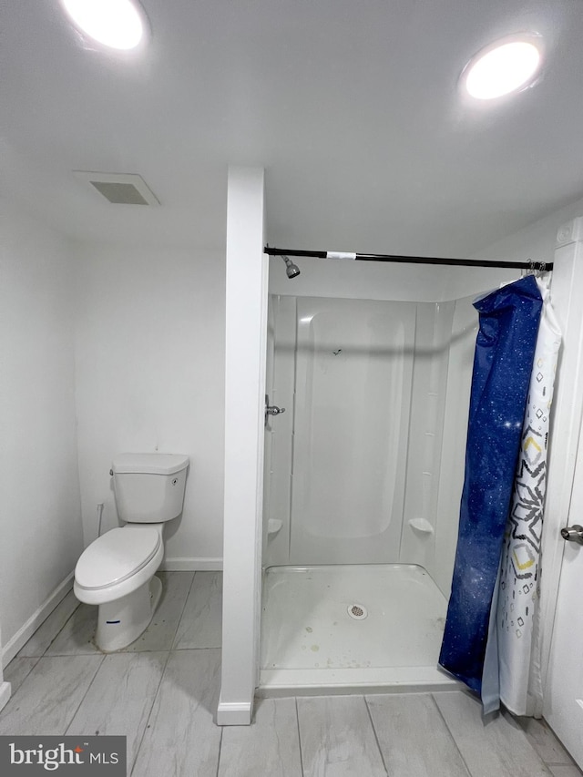 bathroom with toilet and a shower with curtain