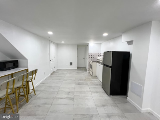 kitchen with white range with electric cooktop and stainless steel refrigerator