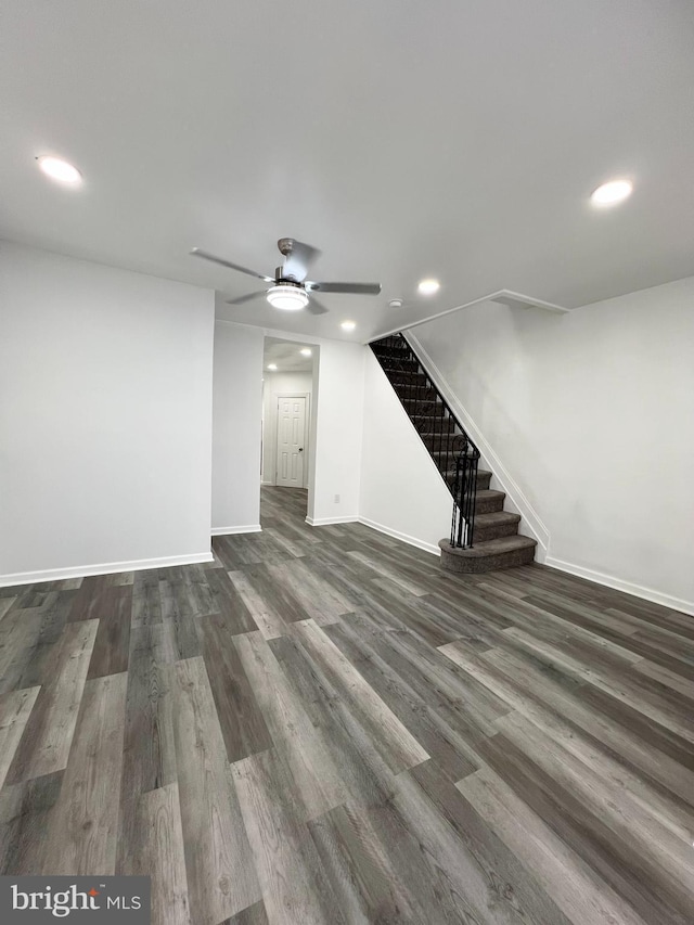 unfurnished living room featuring ceiling fan and dark hardwood / wood-style flooring