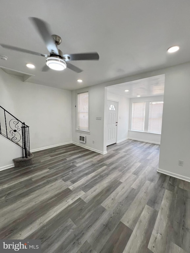 unfurnished living room with ceiling fan and dark wood-type flooring