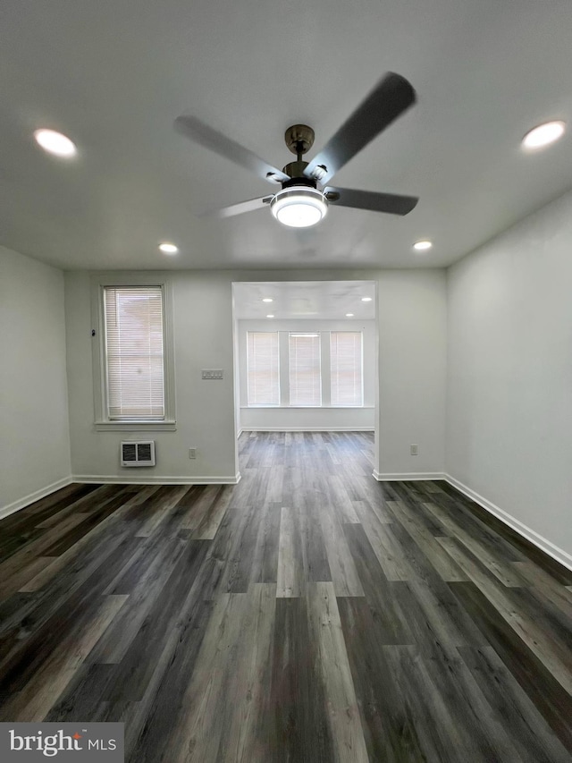 unfurnished living room featuring ceiling fan, a wealth of natural light, and dark hardwood / wood-style floors