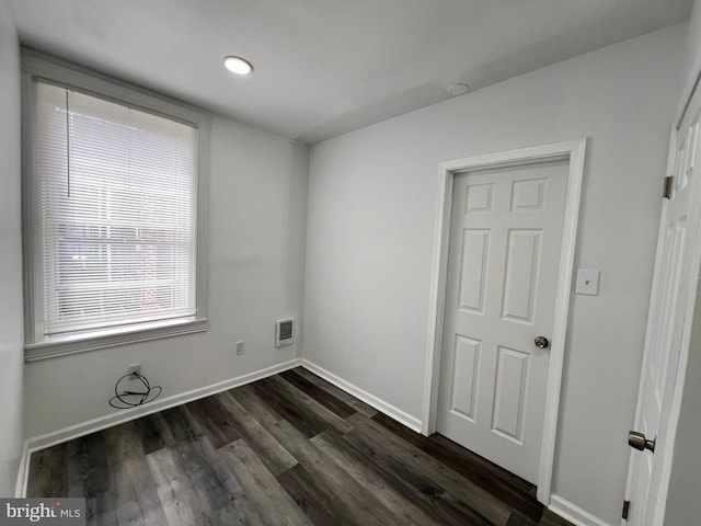 spare room with dark wood-type flooring