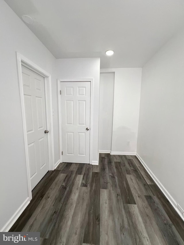 unfurnished bedroom with a closet and dark hardwood / wood-style flooring