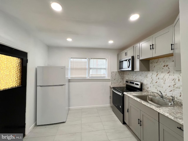 kitchen featuring appliances with stainless steel finishes, gray cabinetry, tasteful backsplash, and sink