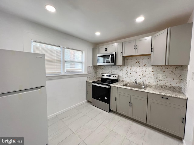 kitchen featuring decorative backsplash, appliances with stainless steel finishes, sink, and gray cabinets