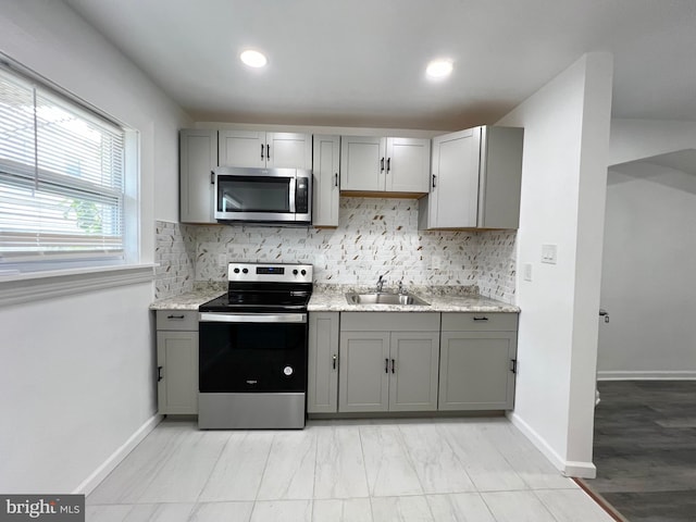 kitchen with decorative backsplash, sink, gray cabinetry, and stainless steel appliances