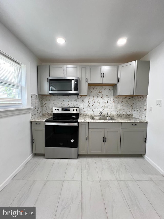 kitchen with stainless steel appliances, tasteful backsplash, and gray cabinets