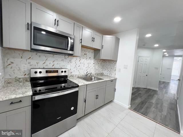 kitchen featuring tasteful backsplash, sink, gray cabinetry, and stainless steel appliances