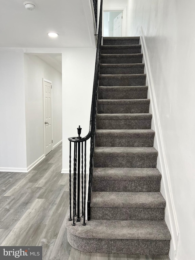 staircase with hardwood / wood-style flooring