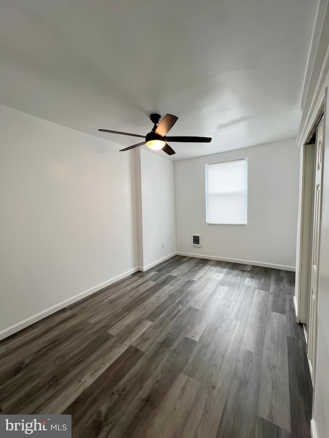 spare room with ceiling fan and dark hardwood / wood-style flooring