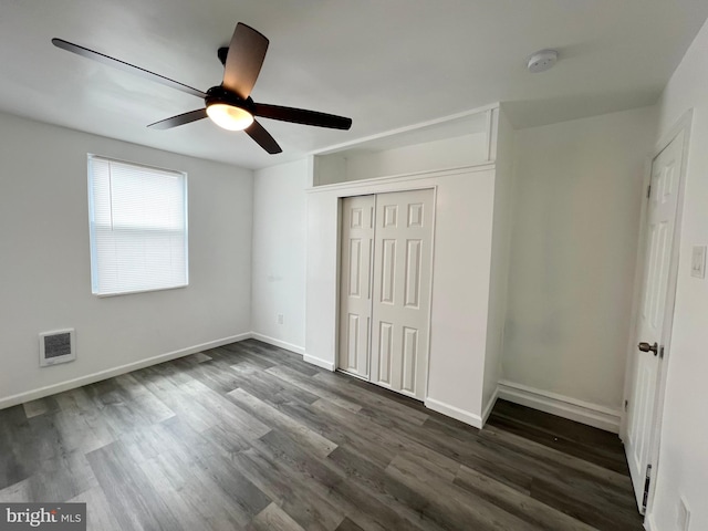 unfurnished bedroom featuring ceiling fan, dark hardwood / wood-style flooring, and a closet