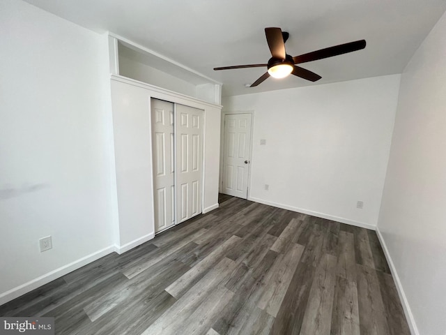 unfurnished bedroom featuring ceiling fan, dark hardwood / wood-style floors, and a closet