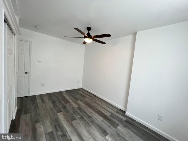 spare room featuring ceiling fan and dark wood-type flooring