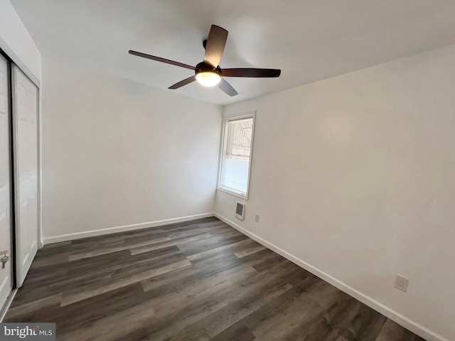 unfurnished bedroom with ceiling fan, a closet, and dark hardwood / wood-style flooring